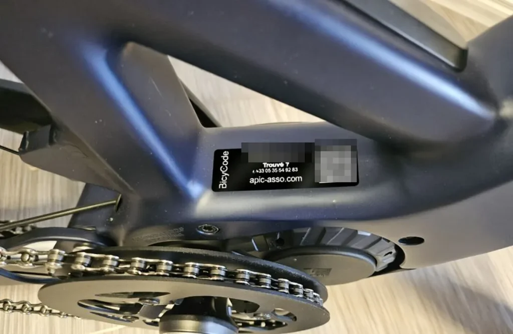 Marquage BicyCode sur le cadre d'un vélo électrique Étiquette de marquage BicyCode collée sous le boîtier de pédalier d'un vélo électrique, avec son numéro d'identification et son QR code